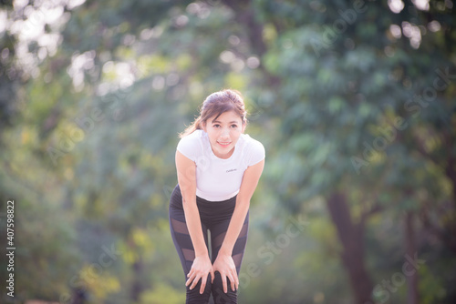 Fototapeta Naklejka Na Ścianę i Meble -  Asian woman is warm up, To make the muscles flexible Before going to jogging for good health and energy metabolism,Outdoors cross training workout. Healthcare concept