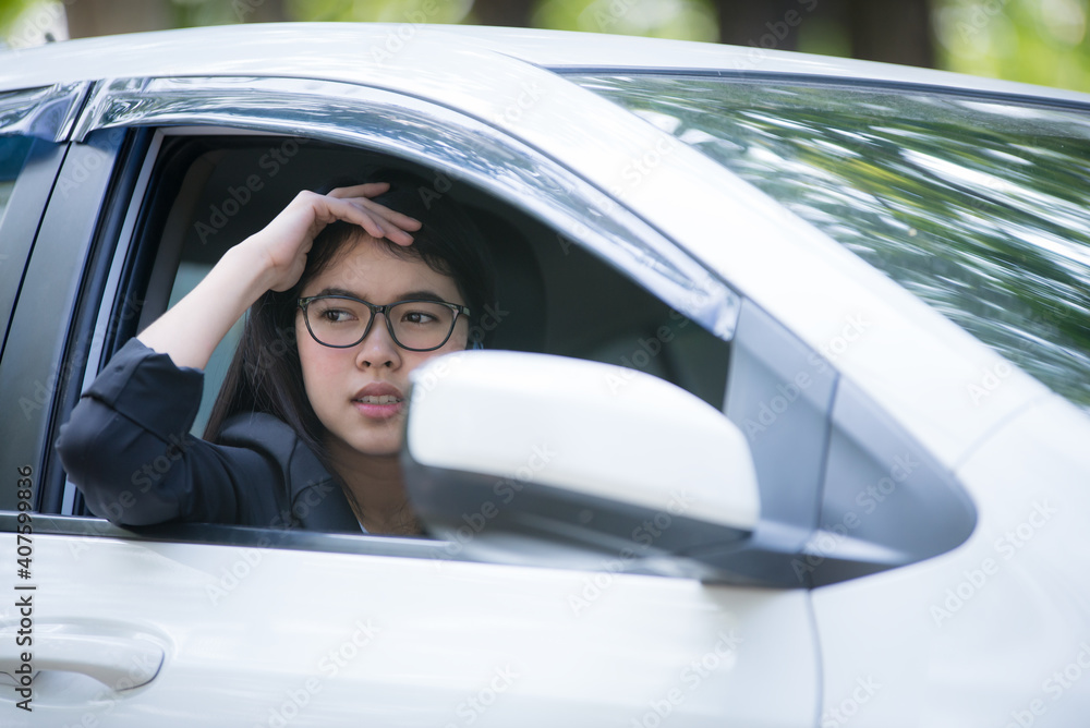The car is broken and parked on the side of the road, the stressful young woman is calling the car mechanic with a mobile phone. The car is broken and parked on the side of the road, the stressful young woman is calling the car mechanic with a mobile phone.
