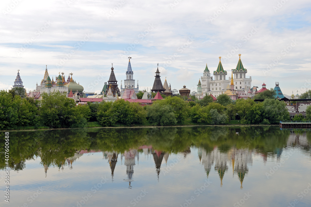 Kremlin in the Moscow district of Izmailovo on a summer day. View of the Izmailovsky Kremlin - a complex of buildings in the old Russian style and their reflection in the water of the pond