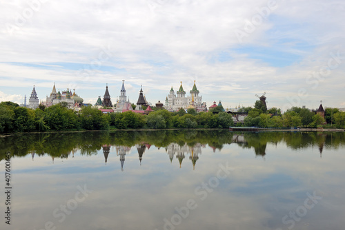 Kremlin in the Moscow district of Izmailovo on a summer day. View of the Izmailovsky Kremlin - a complex of buildings in the old Russian style and their reflection in the water of the pond © FedotovAnatoly