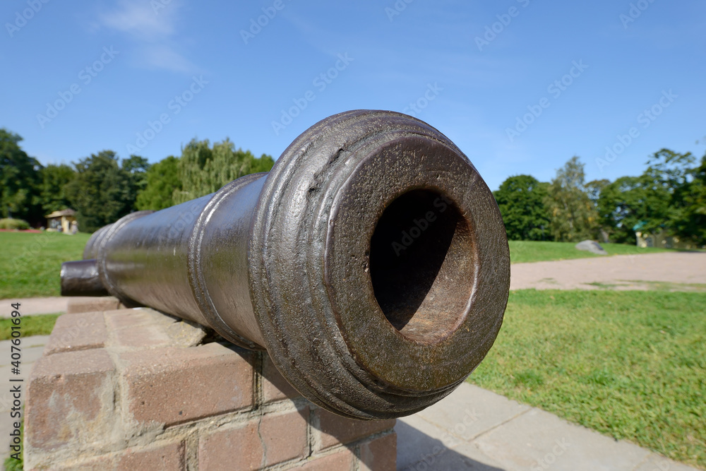 Barrel of an old-fashioned cast-iron cannon. Ancient historical artillery gun