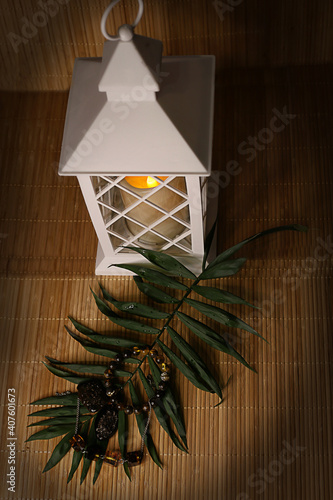 amber products on a leaf of a palm tree against the background of a white lantern, selective focus