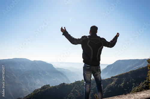 man showing victory at mountain range covered with white mist
