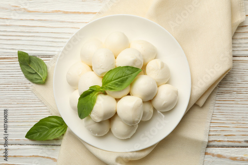 Kitchen towel with plate with mozzarella and basil on wooden background