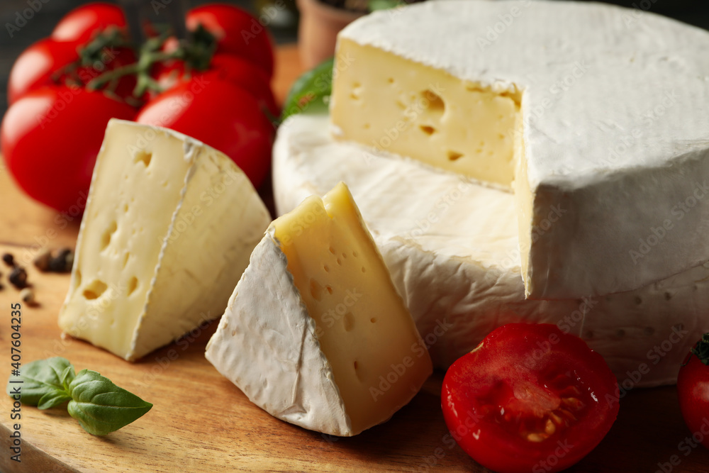 Concept of tasty eating with camembert and spices on cutting board