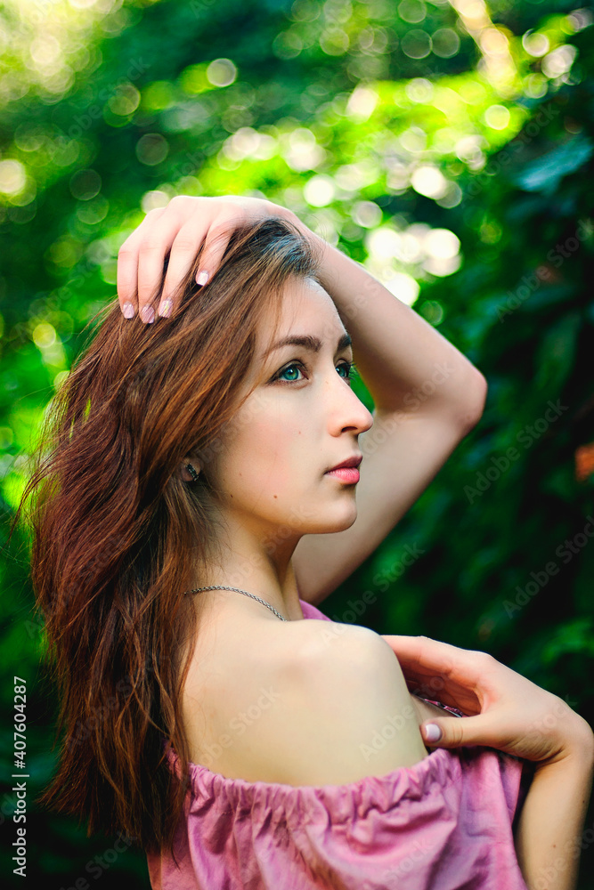 Fototapeta premium Portrait of young beautiful woman in pink dress in spring garden with lilacs. Spring background. Woman's Day. Greeting card.