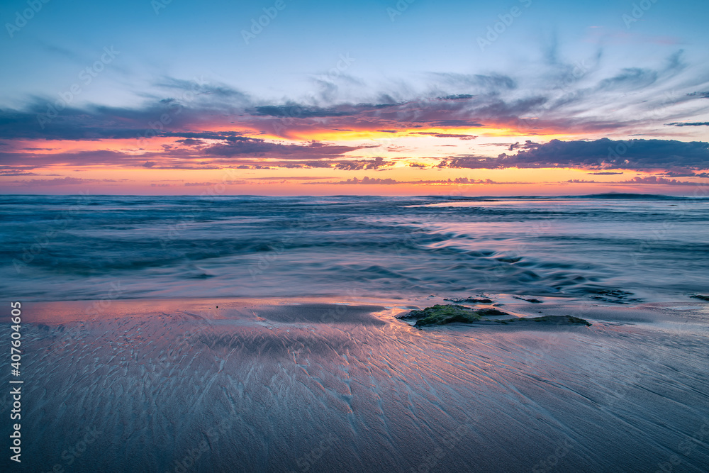 Calm seascape of Australian coastal sunset on the beach, overlooking the ocean with majestic clouds.  Mornington Peninsula, Victoria.