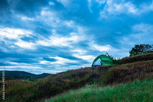 camping solo at mountain top with amazing view and dramatic sky at evening