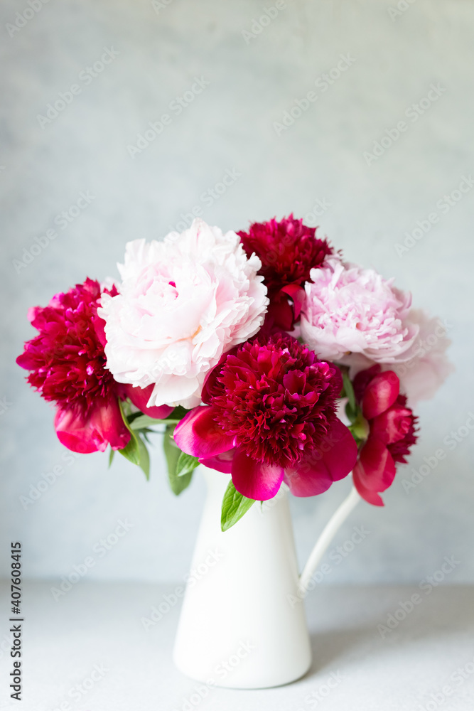 Vase with bouquet of beautiful peonies on table in room, close-up. Bloom. Peony. Postcard. Vase with bouquet of beautiful peonies on table in room, close-up. Bloom. Peony. Postcard.