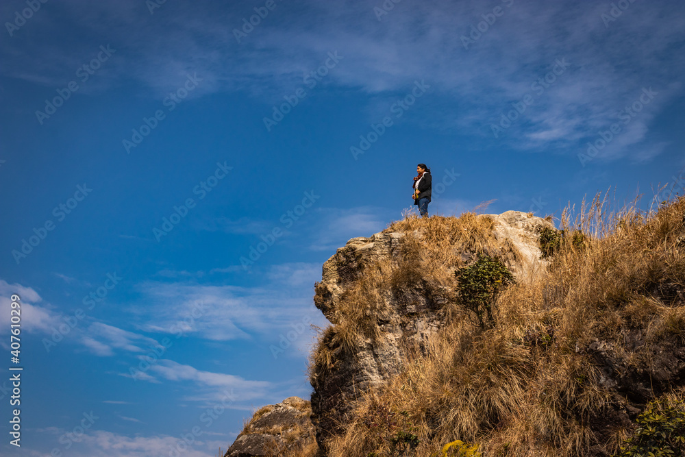 girl watching the beautiful mountain range from edge of mountain