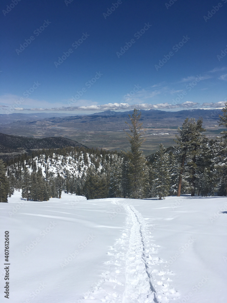 Views of Carson Valley and tracks on the fresh snow on a mountain slope on a sunny winter day