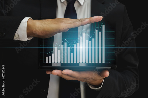 Businessman with financial bar graph marketing on over digital tablet.