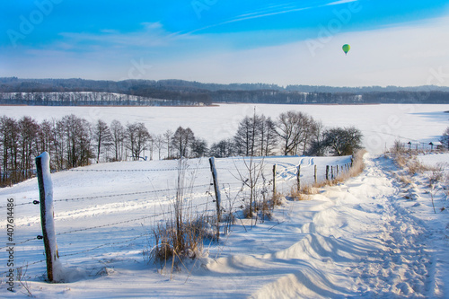 Fototapeta Naklejka Na Ścianę i Meble -  beautiful winter landscape, snow on the field and lake, Balloon in the sky, Masuria in Poland
