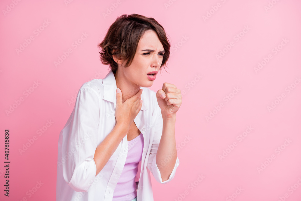 Photo of sad unhealthy young lady wear white shirt coughing fist arm neck isolated pastel pink color background Photo of sad unhealthy young lady wear white shirt coughing fist arm neck isolated pastel pink color background
