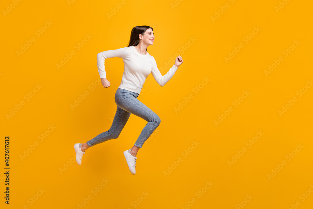 Full size profile photo of hooray nice girl jump run wear sweater jeans sneakers isolated on yellow color background