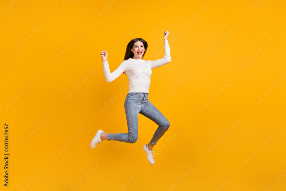 Full size photo of hooray girl jump wear sweater jeans sneakers isolated on yellow color background