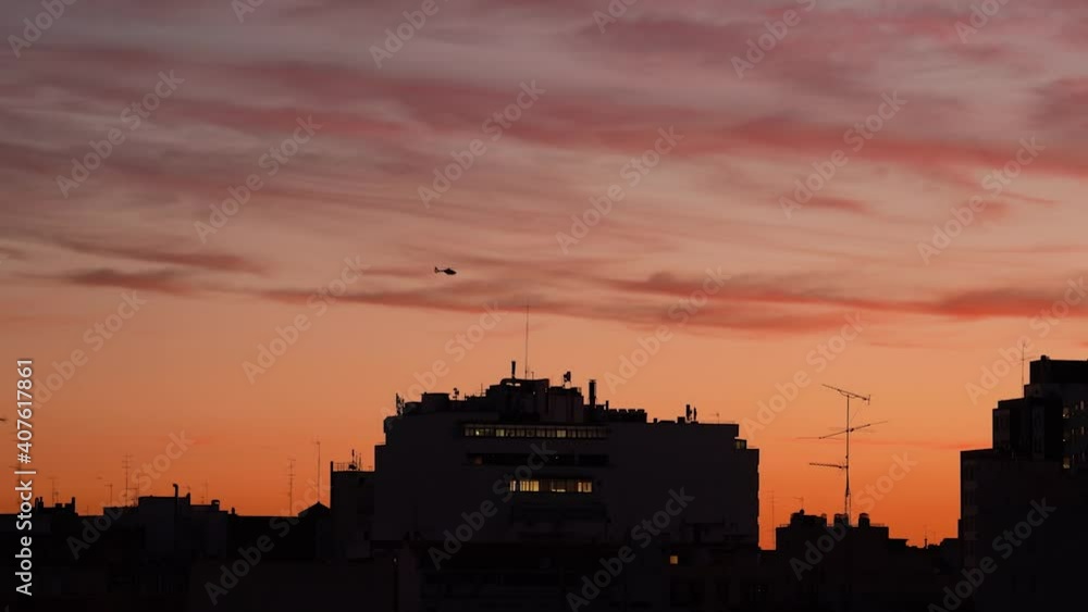 Helicopter against colorful sunset sky over city Helicopter against colorful sunset sky over city