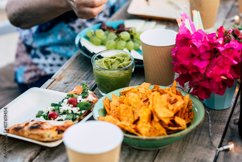 Close up of table full of colorful mexican food like nachos and guacamole or pizza - concept of people eat together and celebrate