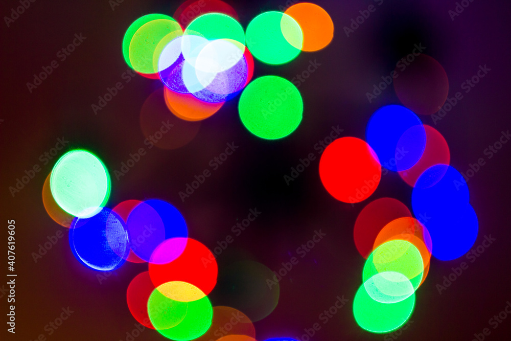 Colorful bokeh of christmas tree garland lights. Blurred festive background with garland. Out of focus new year tree wallpaper