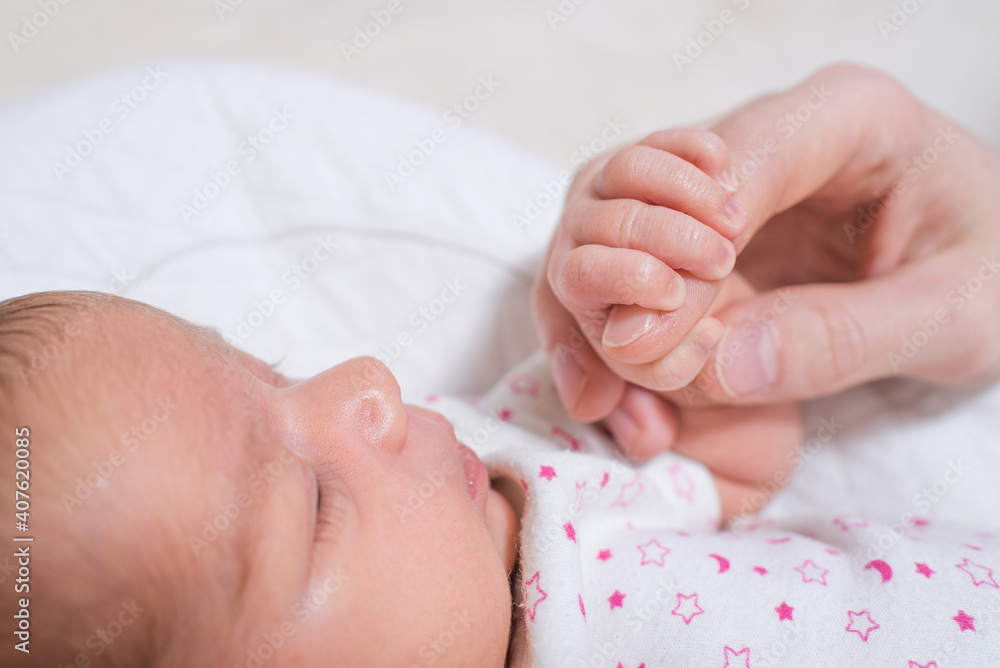 Little hand of a cute, adorable newborn girl holding the hand of her father Little hand of a cute, adorable newborn girl holding the hand of her father
