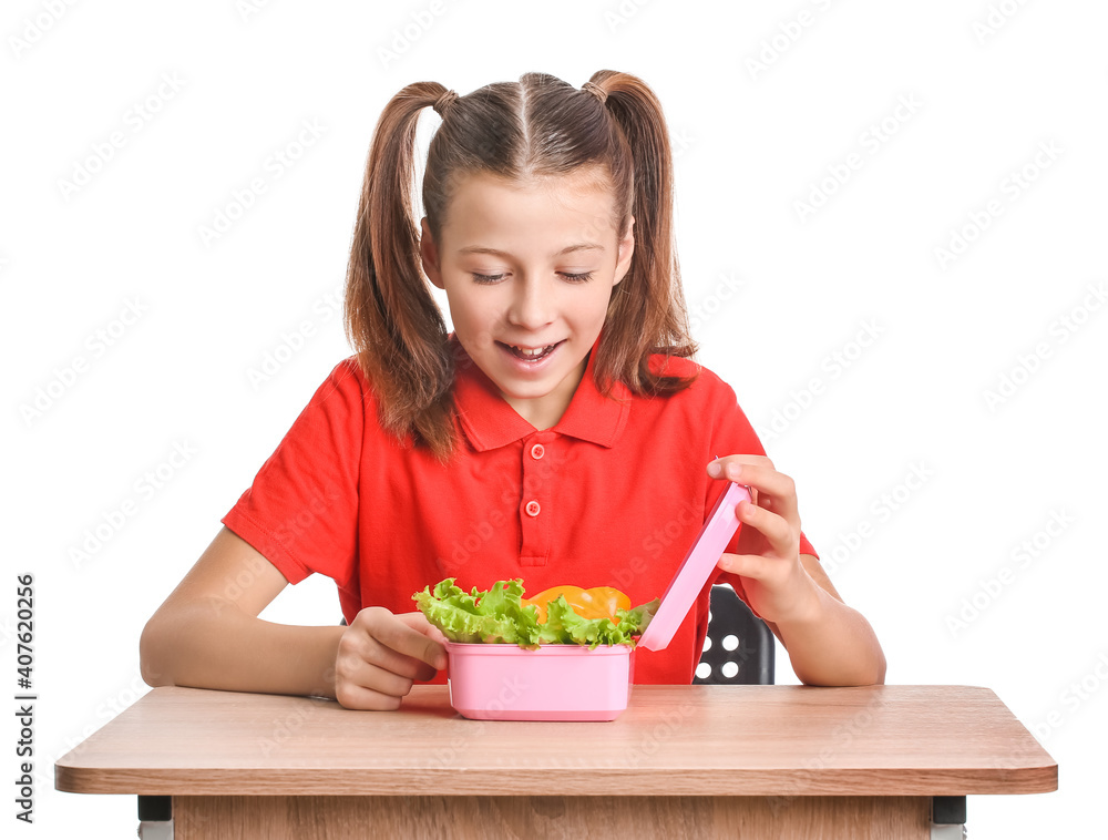 Schoolgirl with lunchbox on desk against white background Schoolgirl with lunchbox on desk against white background