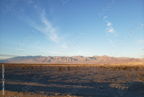Beautiful shot of partly deserted land with rocky mountains on the horizon