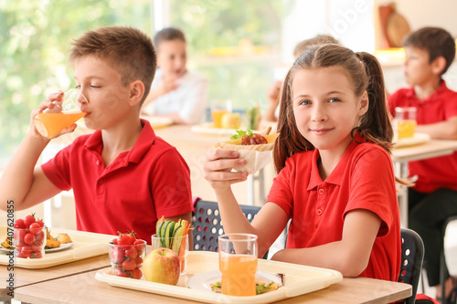 Pupils having healthy lunch in classroom