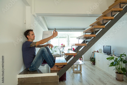 man at home talking on the phone sitting on the stairs
