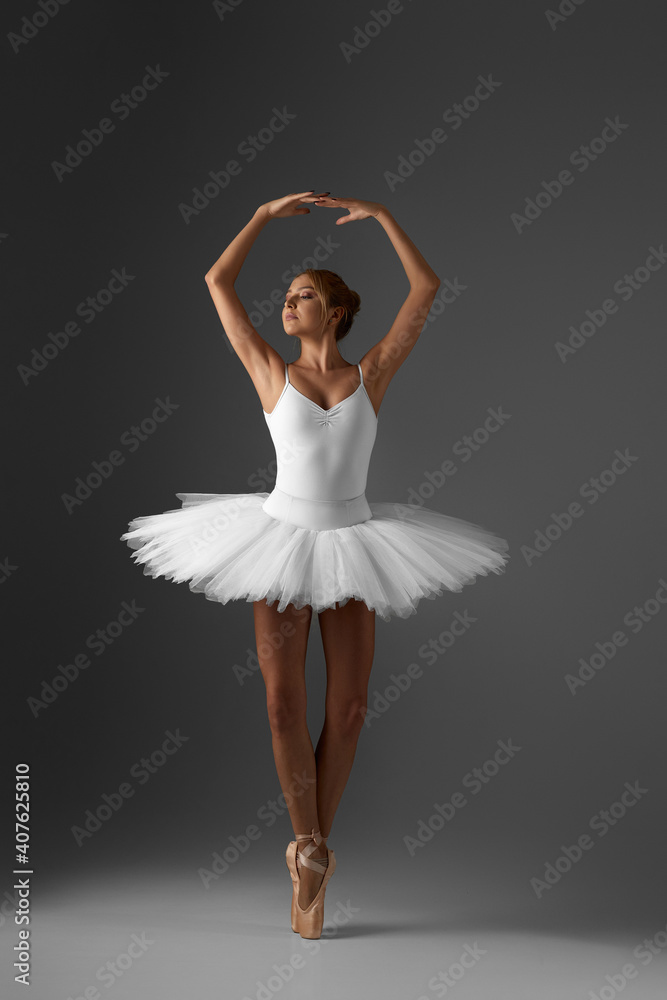 beautiful ballerina in white tutu and pointe shoes dancing on gray background beautiful ballerina in white tutu and pointe shoes dancing on gray background