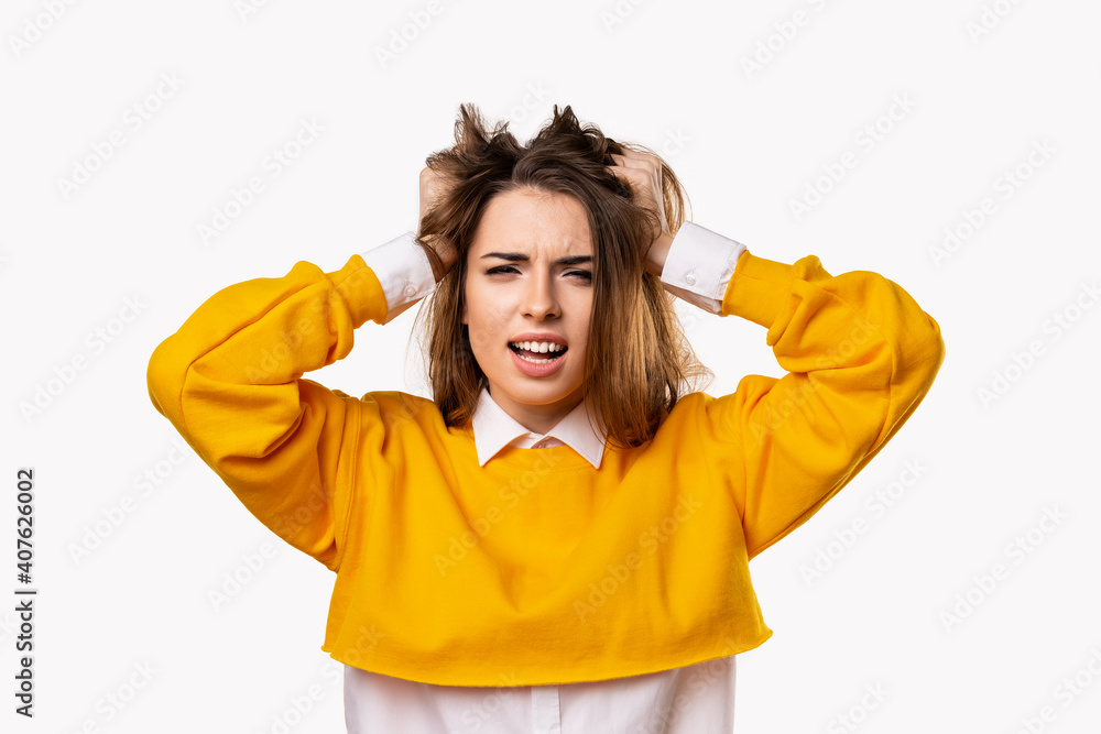 Portrait of woman in panic shouting and grabbing her head in fear or frustration. Studio shot, white background Portrait of woman in panic shouting and grabbing her head in fear or frustration. Studio shot, white background