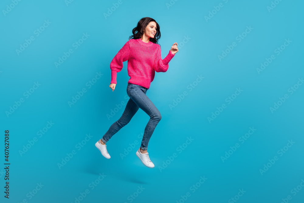Full size profile portrait of pretty lady running jump empty space toothy smile isolated on blue color background