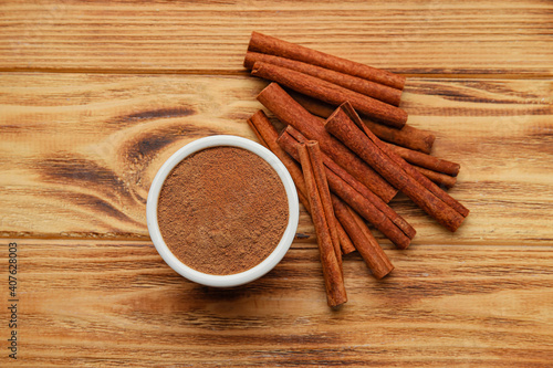 Cinnamon sticks and powder on wooden background