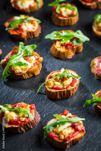 Mini eggplant appetizers with tomato, cheese and salad