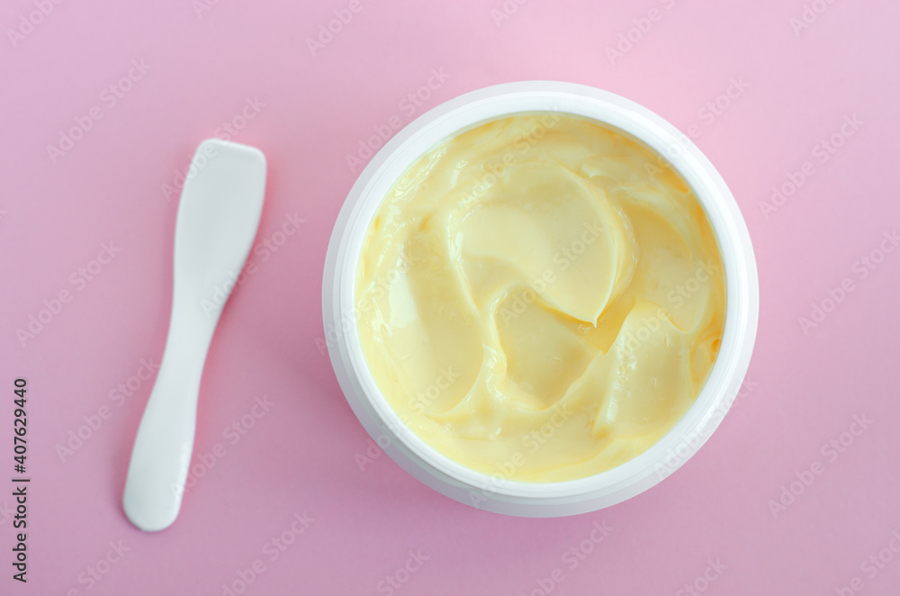 Yellow facial mask (banana face cream, shea butter hair mask, body butter). Natural skin and hair concept. Pink background. Top view, copy space. Yellow facial mask (banana face cream, shea butter hair mask, body butter). Natural skin and hair concept. Pink background. Top view, copy space.