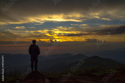 silhouette of a person standing on a mountain top