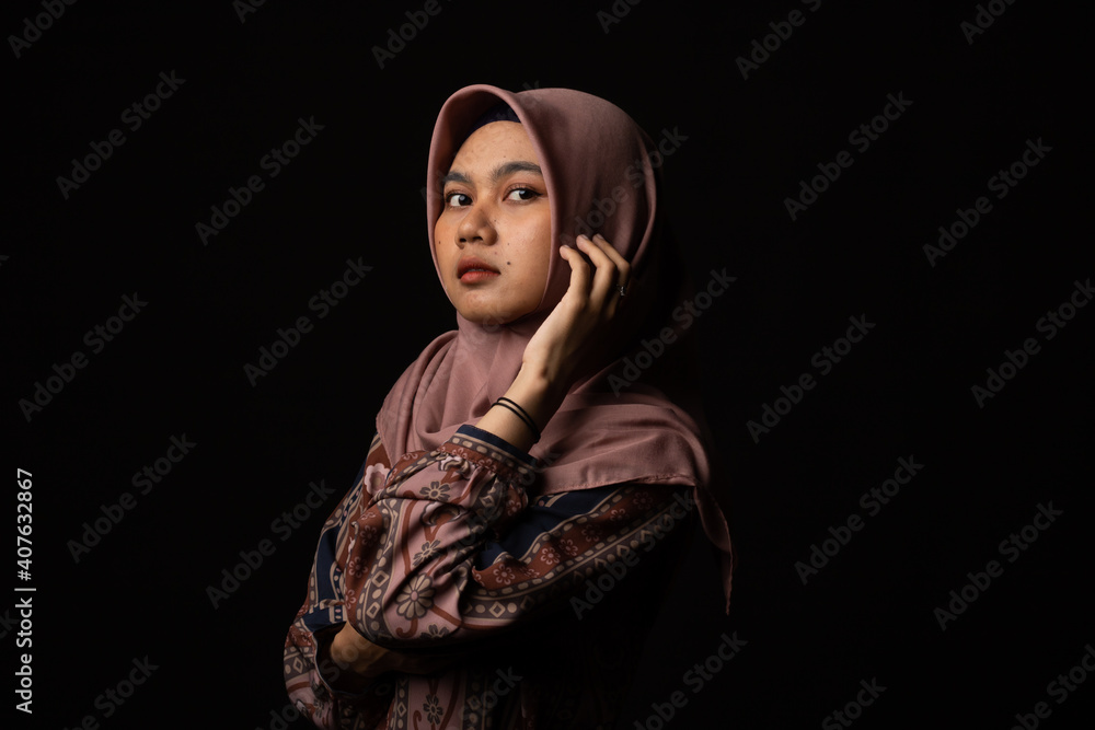 Fashion portrait of young beautiful asian muslim woman with wearing hijab isolated on black background.