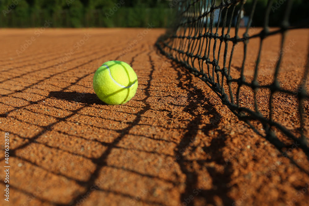 Tennis ball near net on clay court