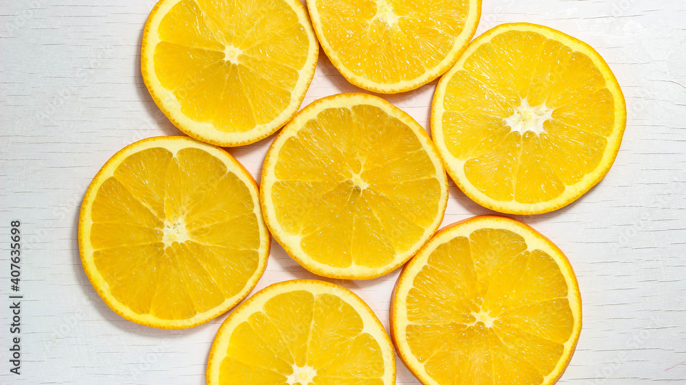A swirling background of sliced oranges on a white background.