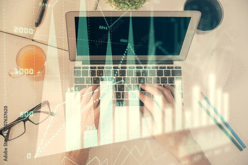 Double exposure of man's hands typing over laptop keyboard and forex chart hologram drawing. Top view. Financial markets concept. Double exposure of man's hands typing over laptop keyboard and forex chart hologram drawing. Top view. Financial markets concept.