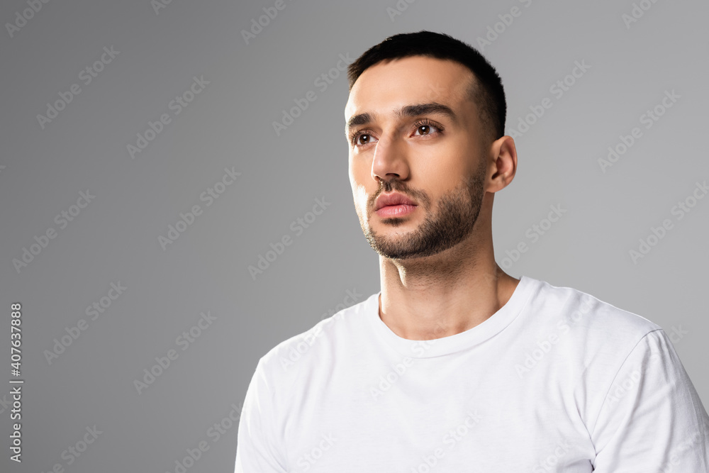 confident, brunette hispanic man in white t-shirt looking away isolated on grey confident, brunette hispanic man in white t-shirt looking away isolated on grey