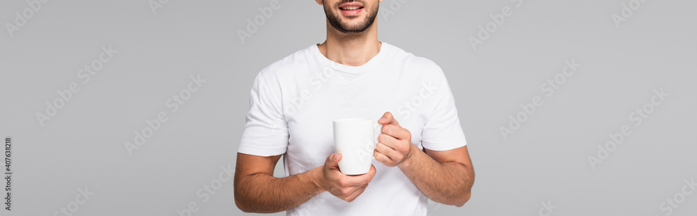 partial view of smiling man in white t-shirt holding cup isolated on grey, banner partial view of smiling man in white t-shirt holding cup isolated on grey, banner