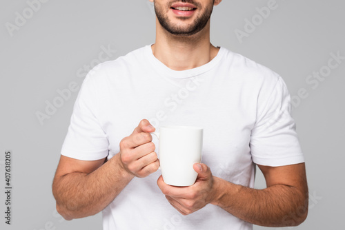 cropped view of man in t-shirt holding white cup isolated on grey