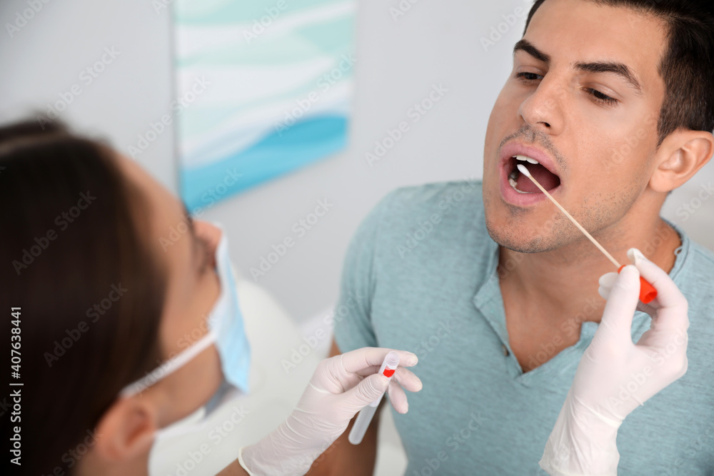 Doctor taking sample for DNA test from man in clinic Doctor taking sample for DNA test from man in clinic