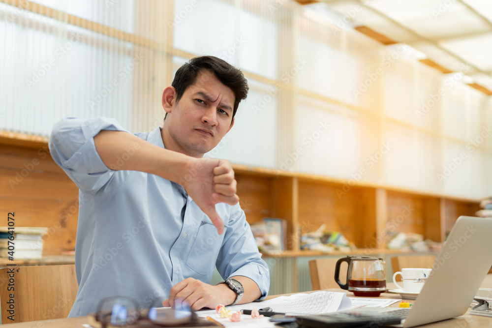 Businessman hand showing thumbs down sign, looking unhappy and angry showing rejection and negative with thumbs down posing. Businessman hand showing thumbs down sign, looking unhappy and angry showing rejection and negative with thumbs down posing.