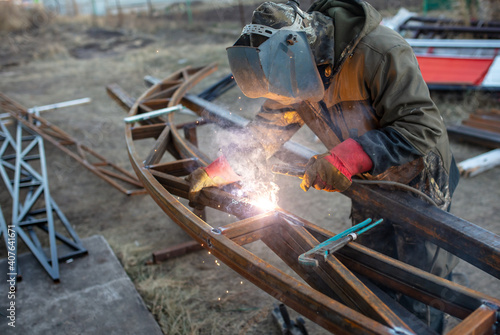 A worker welds metal for a canopy.
