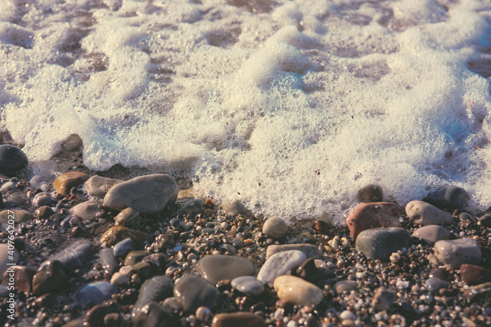 Waves washing over gravel beach, macro shot. Waves washing over gravel beach, macro shot.