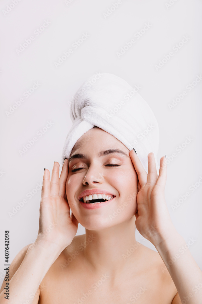 Positive lady enjoys morning spa treatment. Girl after shower posing on isolated background Positive lady enjoys morning spa treatment. Girl after shower posing on isolated background