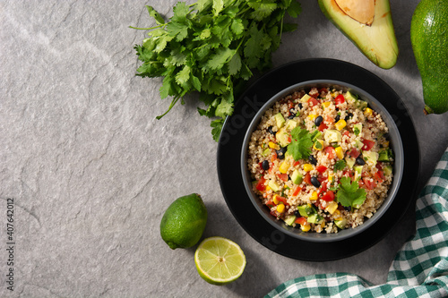 Mexican salad with quinoa in bowl on gray stone. Top view. Copy space