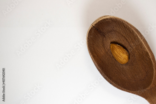 almond in spoon on white isolated background with copy space