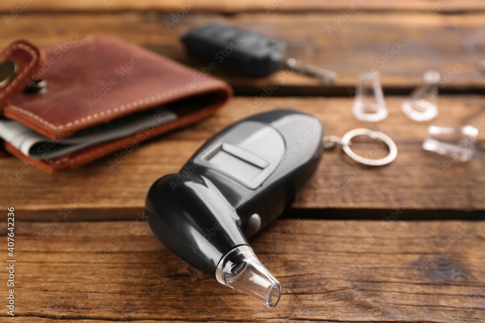 Modern breathalyzer with mouthpiece on wooden table